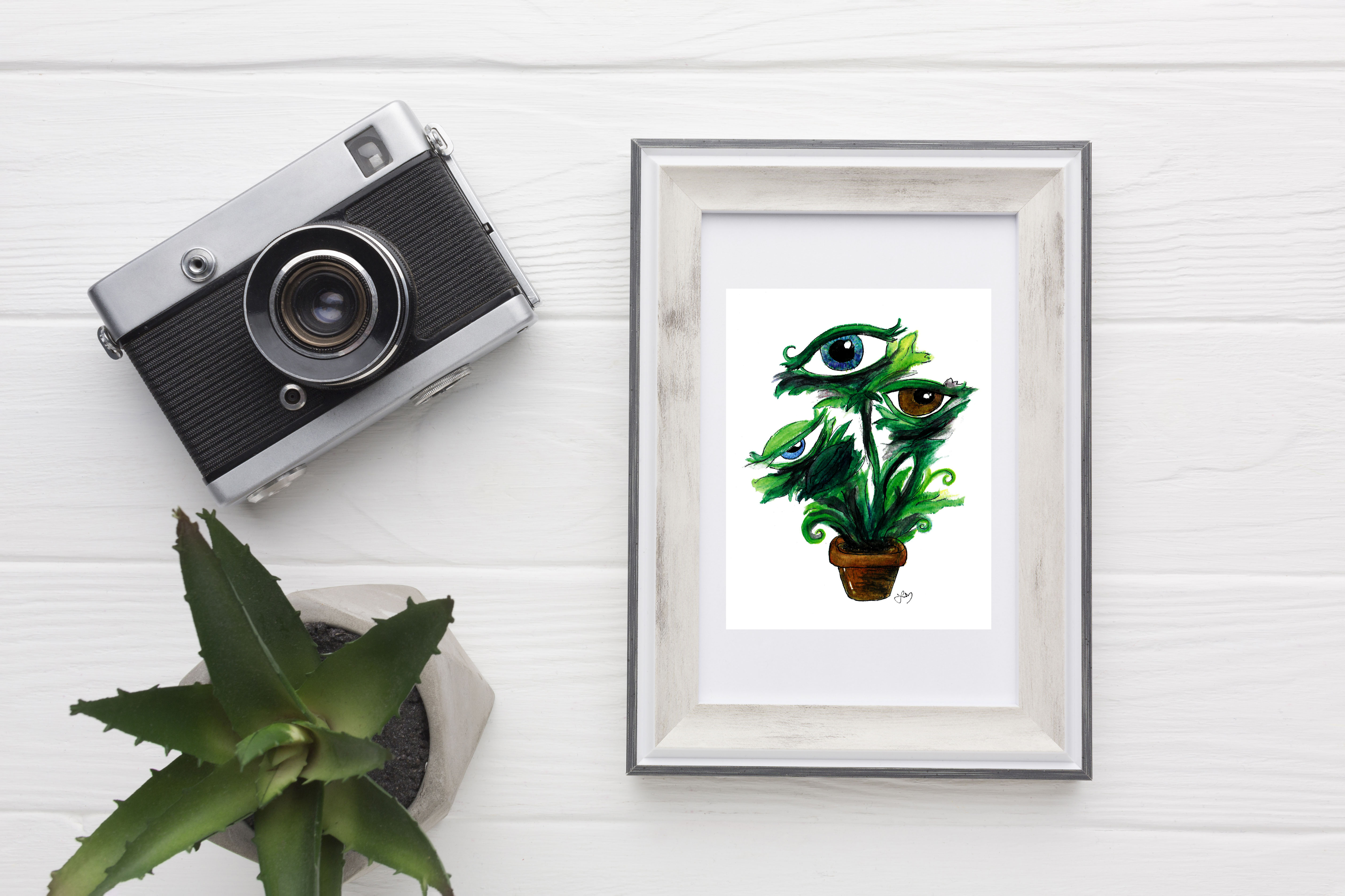 A bright green plant in a brown pot sports brightly colored blue and brown eyes where flowers should be.