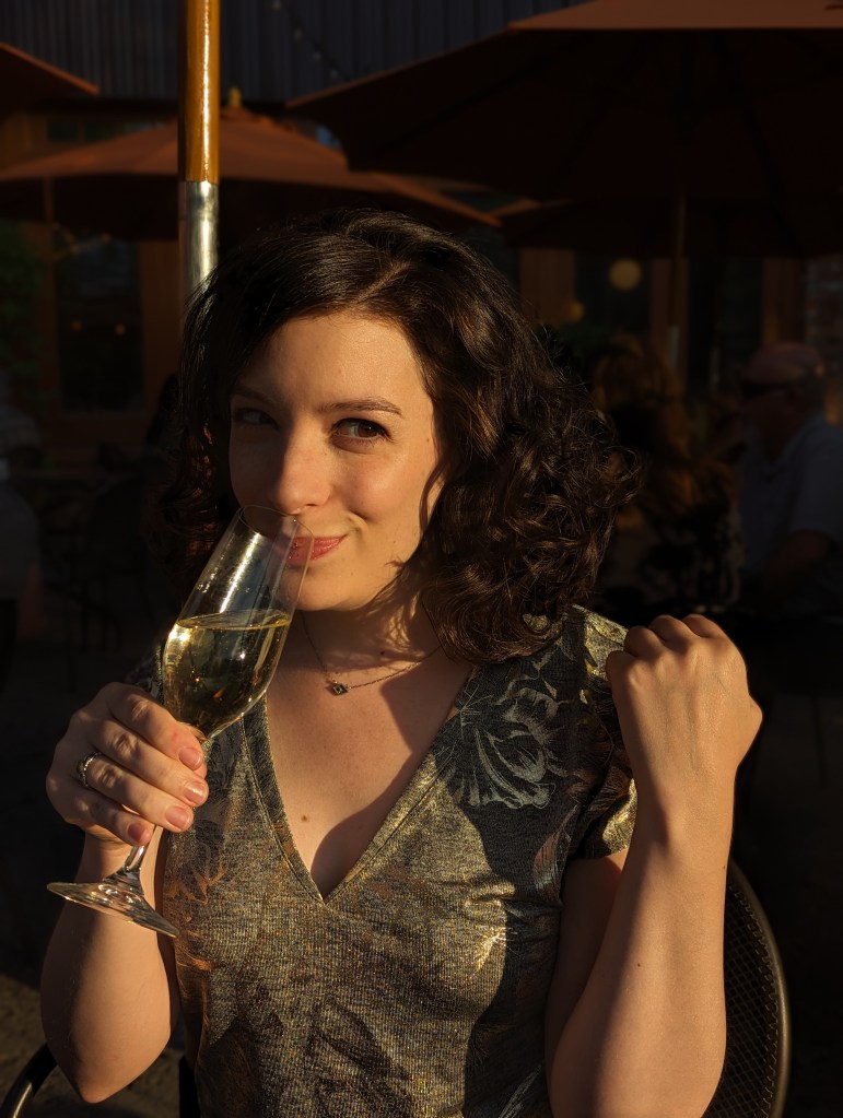 Portrait of Kym Dahl holding a champagne flute.